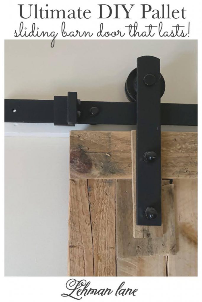 Come check out the Sliding Pallet Barn Door We Made using only 2 Pallets! It brings so much character to our farmhouse without taking up any floor space! #barndoor #palletfurniture #palletprojects #palletdoor https://lehmanlane.net