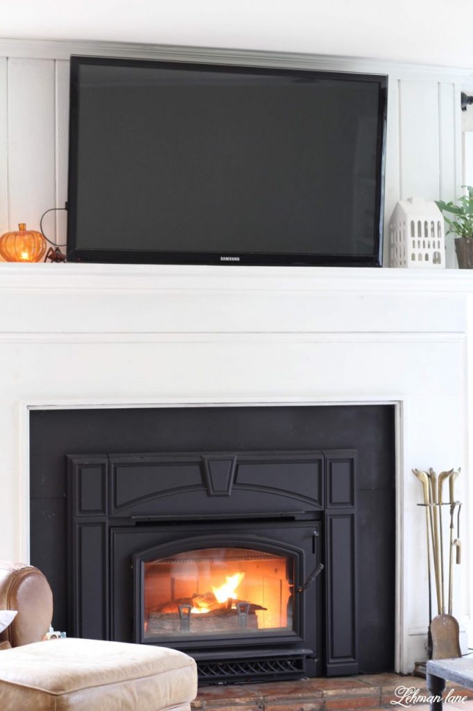 Sharing all of our tips, tricks & ideas for a easy awesome fireplace makeover ideas from our family room fireplace makeover with before & after pictures on a budget & 3 reasons why we decided to paint our fireplace black! #fireplacemakeover #whitefireplacewithtv https://lehmanlane.net